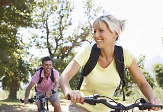 Middle Aged Couple Cycling Through Countryside