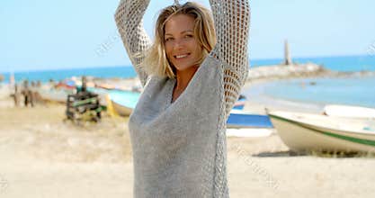Woman in Grey Sweater on Beach with Fishing Boats