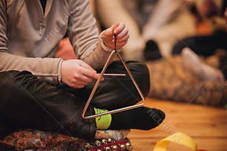 Girl playing a musical triangle