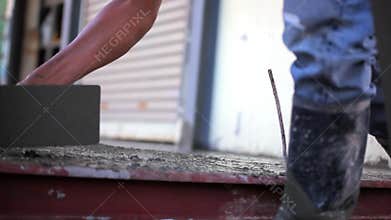 Closeup of mason's hand spreading concrete mix