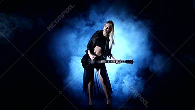 Headbanging woman plays guitar at the concert