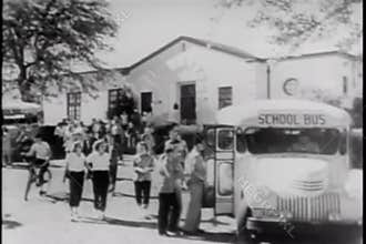 Wide shot of students boarding school bus