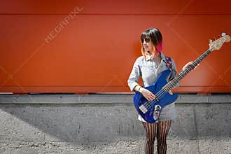 Female bass guitar player posing with blue bass