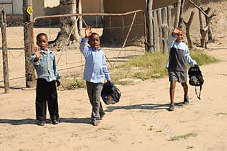 three waving african school boys