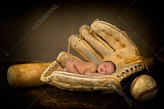 Newborn baby in baseball glove