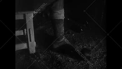 Drunken man picking up glass bottle and throwing towards wooden door