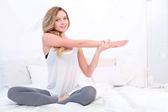 Woman stretching her body in bed