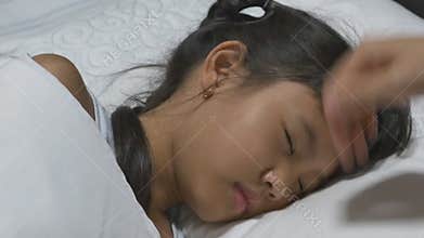 Asian child sick and sleeping on the bed