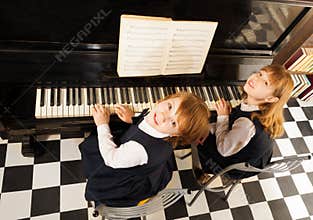 View from top of girls in uniforms playing piano