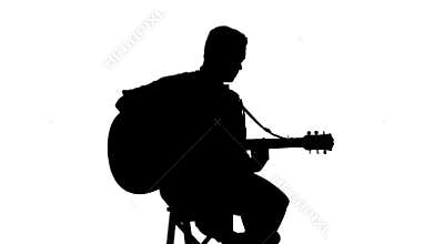Silhouette of sitting man playing the guitar on a