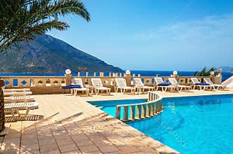 Amazing view on swimming pool area and sunbeds under palm tree w