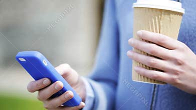 Woman hands with coffee cup and smartphone