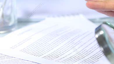 Looking through a magnifying glass to contract and hand signature