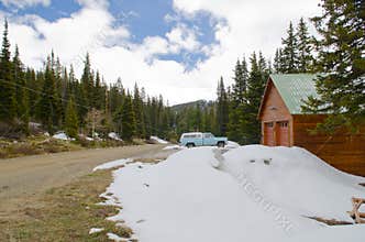 Old car and house and snow around in Colorado