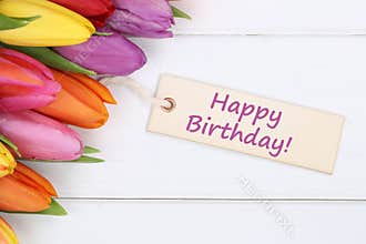 Happy birthday with tulips flowers on wooden board