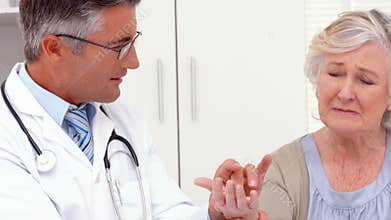 Doctor examining hand of patient