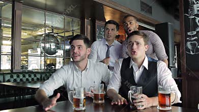 Four friends businessmen drink beer and rejoice