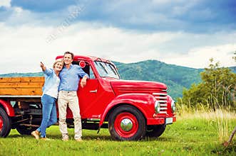 Senior couple with red car