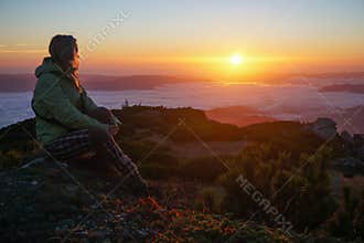 Woman enjoying the sunrise in the mountains