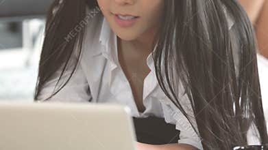 Woman working with her notebook lying on floor