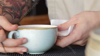 Hand of barista making latte