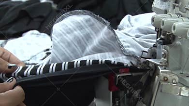 Textile Garment Factory Workers: CU feeding striped fabric into sewing machine