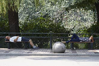 Weary visitors sleeping on public chairs