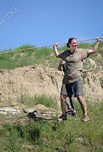 Female competitor crossing tight wire screeming trying to hang on.