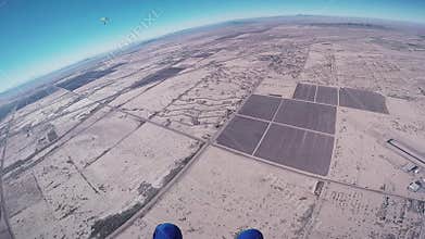 Professional skydiver opens parachute in air, fly above Arizona. Sunny day.
