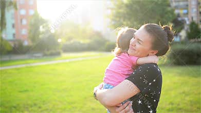 Mother and child are hugging and having fun outdoor in nature, Happy cheerful family. Mother and baby kissing, laughing