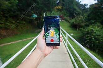 Hand holding a cellphone playing Pokemon Go