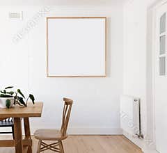 Blank framed print on white wall in danish styled interior dining room