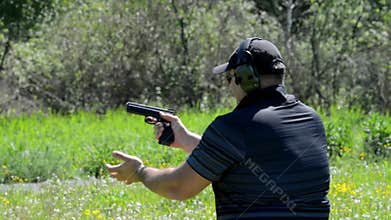 Man shoots with a gun in targets on shooting range.