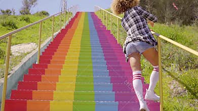 Young woman walking up a colorful flight of steps