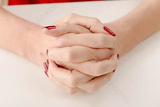Woman cross hands on table