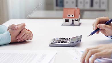 Woman and realtor counting on calculator