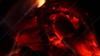 Bright burning wood in campfire. Glowing wood logs and coals in fire
