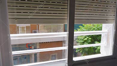 Metal window shutters are raised up.