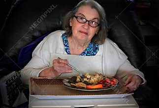 Elderly woman eating dinner