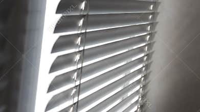 Sunlight coming through venetian blinds by the window