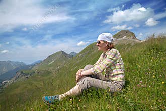 Woman is sitting on a mountain