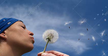 Girl blowing a dandelion