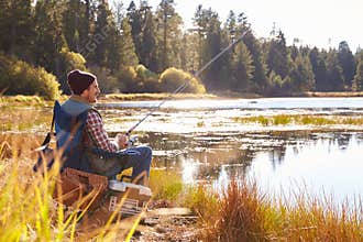 Mid-adult man fishing by lakeside, Big Bear, California, USA