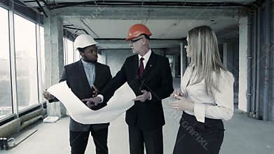 Men, woman in suit and helmet discuss blueprint, communicate with buyer. Chief engineer builder
