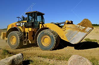 Caterpillar front end loader carrying sand