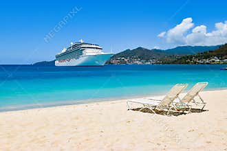 Cruise ship in Caribbean Sea with beach chairs on white sandy beach. Summer travel concept.