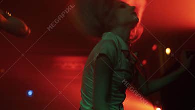 Girl in nurse halloween costume dance on scene at night club party