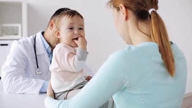 Happy woman with baby and doctor at clinic