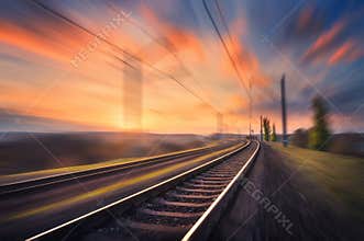 Railroad in motion at sunset. Blurred railway station
