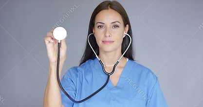 Attractive doctor holding up a stethoscope